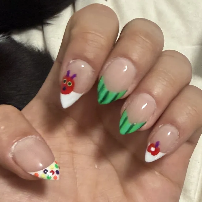 Almond French tips with a hand-painted ladybug, watermelon-stripe tips, a cherry and a fruity confetti tip