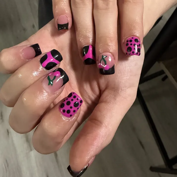 Short square nails with black French tips, hot pink polka dots and hand-painted cherries