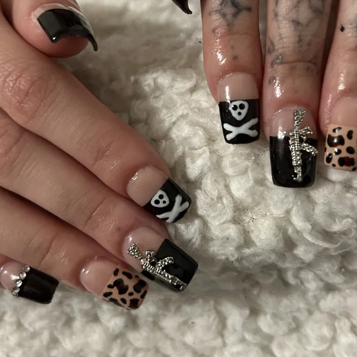 Black coffin nails with white skulls, rhinestone accents and leopard print accent nails
